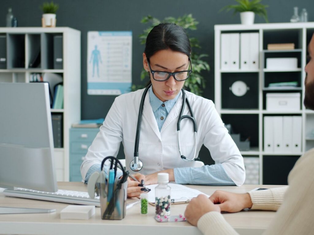 A doctor consulting with a patient at a clinic desk